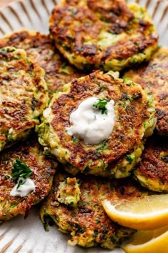 a plate topped with crab cakes and lemon wedges