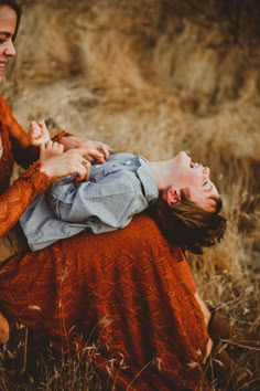 two women are playing with each other in the grass while one woman is holding her