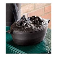 a black pot sitting on top of a green table