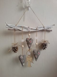 an ornament hanging from a wall with pine cones