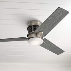 a ceiling fan with a light on top of it in a room that is painted white