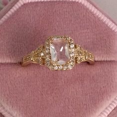 an engagement ring with a large pink stone surrounded by small white and yellow diamond accents