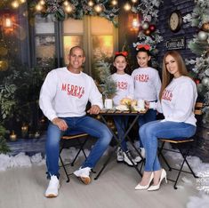 three people sitting at a table with food in front of them and christmas decorations behind them