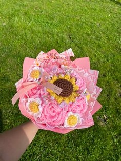 a person holding a pink and yellow flower bouquet in their hand with the words happy birthday written on it