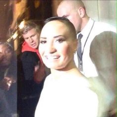 the woman is smiling and posing for a photo with other people behind her on instagram