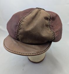 Handmade and hand stitched six panel Leather newsboy hat in maroon and tan.  Hat is sized at 23.6 inches on the inside with a little stretch.  If you have any questions please message before purchase. Brown Leather Curved Brim Baseball Cap, Classic Brown Flat Cap Baseball Cap, Classic Brown Baseball Cap, One Size Fits Most, Classic Brown Baseball Cap One Size Fits Most, Classic Brown Six-panel Baseball Cap, Brown Brimmed Baseball Cap, Brown Flat Cap, One Size Fits Most, Adjustable Brown Baseball Cap With Short Brim, Vintage Brown Baseball Cap One Size Fits Most