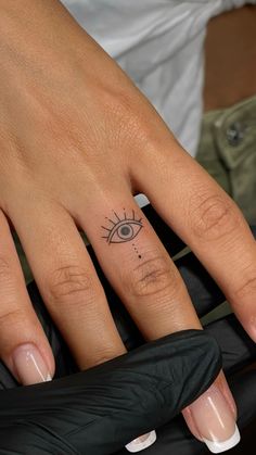 a woman's hand with an eye tattoo on it