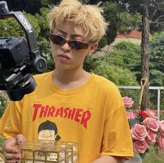 a young boy holding a camera and a box with an object in it's hand