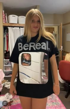 a woman standing in front of a refrigerator wearing a t - shirt that says be real