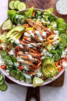 a salad with chicken, carrots, cucumbers and ranch dressing