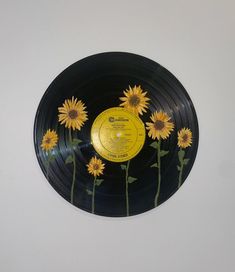 a vinyl record with sunflowers on it is mounted to the wall in front of a white wall