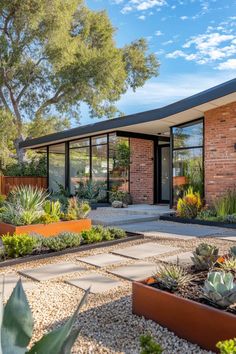 a modern house with lots of plants in the front yard