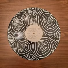 a black and white record on a wooden table