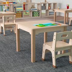 children's wooden table and chairs in a playroom with bookshelves, desks and toys