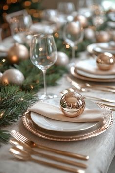 the table is set with white and gold plates, silverware, and christmas decorations