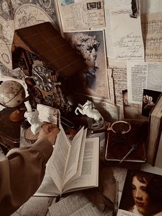 an open book sitting on top of a pile of books next to a clock and other items