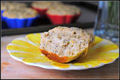 a muffin on a yellow and white plate next to cupcakes