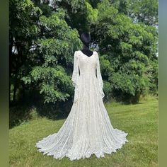 a white wedding dress on display in the grass