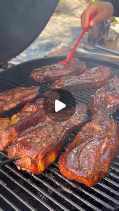 steaks being grilled on the grill with tongs