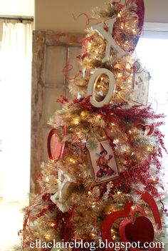 a christmas tree decorated with red and white ornaments, hearts, and pictures on it