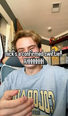 a man is sitting down with his hand on his chest and the caption reads nick's a confined swiftie