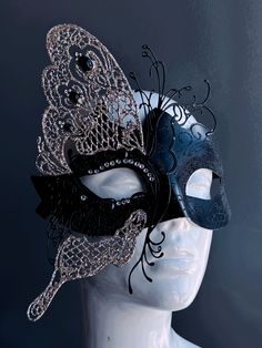 This glittering mask takes on the shape of a butterfly, symbolizing transformation and grace. The striking contrast of black and silver exudes an air of opulence and charm, while shimmering rhinestones adorn the mask. Whether you're attending a grand masquerade ball or a themed gala this mask ensures you'll be the center of attention. Age Group/Gender - Adult/Women Size/Type - One size fits all adults Mask Color - Black/Silver Mask Material - Polyresin and laser cut metal Elegant Black Formal Mask, Elegant Black Mask For Costume Party, Elegant Black Eye Mask, Elegant Black Masks And Prosthetics For Party, Elegant Black Masks And Prosthetics For Evening, Elegant Black Party Masks And Prosthetics, Elegant Black Eye Mask For Masquerade, Silver Gothic Eye Mask For Masquerade, Elegant Silver Eye Mask