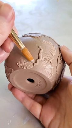 someone is painting the inside of an egg with a paintbrush in their left hand