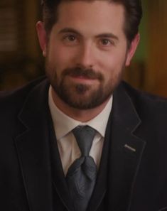 a man with a beard wearing a suit and tie