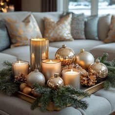 a tray filled with candles and ornaments on top of a couch