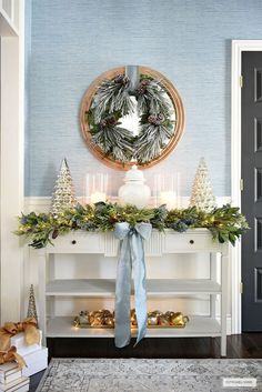 a christmas mantle decorated with greenery and candles