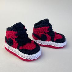 a pair of red and black crocheted shoes with the words black / red written on them