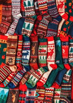 many different colored socks with moose and snowflakes on them, all lined up next to each other