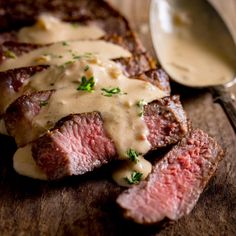 grilled steak with gravy on wooden cutting board