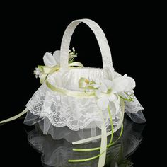 a white flower girl basket with lace and flowers