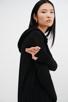 Meet our Oslo Tunic, the definition of elevated loungewear. Fashioned from soft and high-stretch sheer European jersey, she offers comfort that you can live in for days on end. Oslo updates the tunic silhouette with stunning details, such as an oversized hood and a draped, high-low hem that dips at the back. Her dropped shoulders extend to relaxed long sleeves, complete with thumbholes for a cozy, finishing touch. Shop also her best-selling sister hoodie, Firenze, crafted from our European Frenc Fitted Black Top For Lounging, Black Fitted Top For Lounging, Black Fitted Tops For Lounging, Black Top For Lounging In Fall, Versatile Relaxed Fit Tops For Lounging, Versatile Black Loungewear Tops, Versatile Black Tops For Daywear, Versatile Tops For Lounging In Fall, Stretch Tops For Daywear In Winter