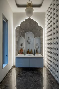 a white room with blue cabinets and sculptures on the wall, along with round holes in the ceiling