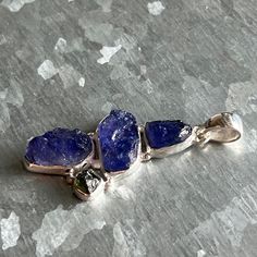 "Tanzanite Rough & Genuine Moldavite Pendant in 925 Sterling Silver and 1 3/4\" in Height (including the bail). ✓You'll receive your new pendant in the signature gift box ✓Tanzanite Rough & Genuine Moldavite ✓Because of the natural crystal structure, natural gemstones could have some small visible scars and crackles. ✓ Solid 925 Sterling Silver (925 parts per 1000) ✓ Silver Hallmark on every item ✓ Handcrafted ✓ Every natural stone is different and exclusive in pattern and shape, and with its un Unique Tanzanite Jewelry For Gifts, Unique Tanzanite Jewelry Gift, Handmade Tanzanite Jewelry For Gifts, Handmade Tanzanite Jewelry Gift, Silver Tanzanite Jewelry Gift, Tanzanite Meaning, Sterling Silver Pendant Gemstones For Healing, Tanzanite Oval Pendant Necklace With Gemstone, Silver Tanzanite Pendant Jewelry