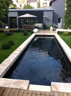 an outdoor swimming pool in the middle of a yard