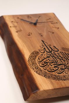 a wooden clock with arabic writing on it