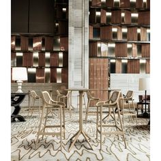 a room filled with lots of chairs and tables in front of a wall covered in wooden panels