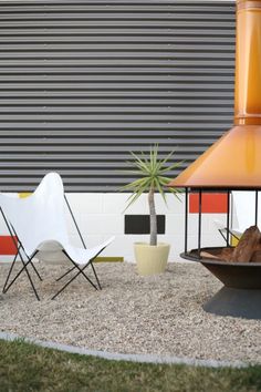 two chairs and a fire pit in front of a building