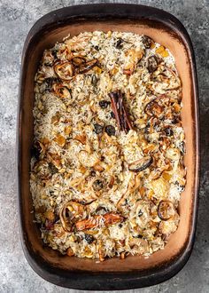 a casserole dish filled with rice, raisins and other toppings