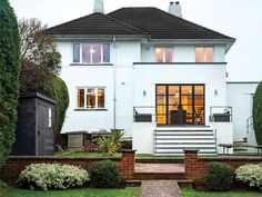 a large white house sitting on top of a lush green field