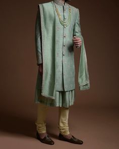 Item Contains:  Sherwani kurta and pyjama  All accessories are additional  Fabrics :   Banarsi silk  Colours :  Pista Green Style and Designs : Sherwani Sherwani has mandarin collar and long sleeves with a full button placket symmetric hem and multiple slits it has embroidered collar button it's small motifs of zardosi all over the sherwani and has zari zardosi work on collar buttons and sleeves edges  Kurta  It come with an anarkali kurta that has frills and mandarin collar and long sleeves  Pa Formal Pista Green Bandhgala With Resham Embroidery, Pista Green Sherwani For Formal Eid Celebrations, Formal Pista Green Sherwani For Eid, Traditional Pista Green Kurta With Naqshi, Traditional Naqshi Kurta In Pista Green, Pista Green Naqshi Kurta For Festivals, Pista Green Bandhgala With Traditional Drape, Pista Green Bandhgala With Dabka, Festive Straight Kurta Sherwani With Naqshi