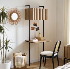 a room with a chair, desk and mirror on the wall next to a potted plant