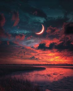 a crescent moon is seen in the sky over water at sunset with clouds and grass