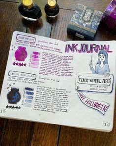 an ink journal is open on a wooden table with bottles and other items around it