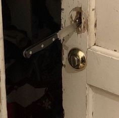 an open door with a metal handle on it's left side and the bottom part of the door frame missing