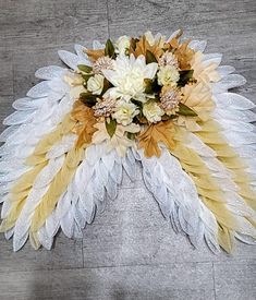 an arrangement of flowers and feathers on the floor