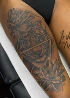 a woman's leg with a tiger and lotus tattoo on it